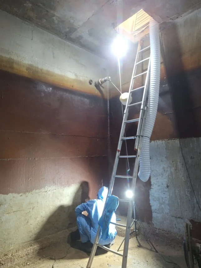 Equipe no interior da cisterna com acesso de manutenção restrito